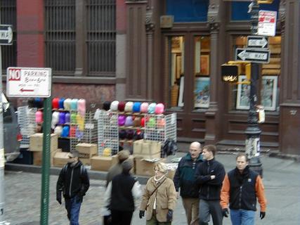 Coloured wigs for sale on the street<br>Location: <a href="https://www.google.com/maps/search/?api=1&query=40.72383,-74.00043" target="_new">New York City Tour, Spring St and Greene St</a>